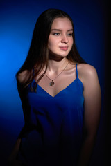 Naklejka premium portrait of a beautiful girl in a dress in the Studio with a blue filter