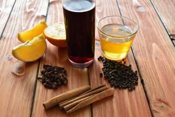 Glintwein of red wine with: orange, cinnamon, pepper, cloves and honey on a wooden background