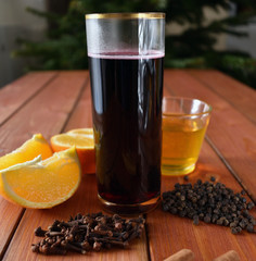 Glintwein of red wine with: orange, cinnamon, pepper, cloves and honey on a wooden background