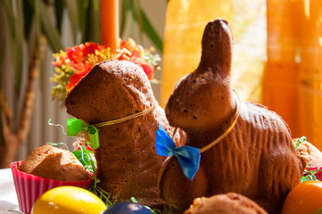 A table decorated for celebration of the easter, with coloured eggs and baked rabbit and sheep....