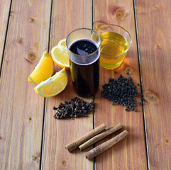 Glintwein of red wine with: orange, cinnamon, pepper, cloves and honey on a wooden background