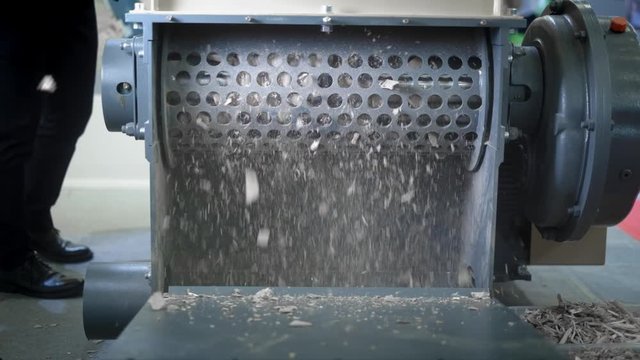 Woodworking Machine. Schroeder grinds wooden boards. Woodworking industry. Fly chips and sawdust. Destruction of logs.
