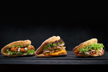 Closeup three different Appetizing sandwiches or burgers on wooden background