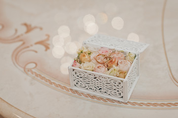 Wedding rings in a stylish box on a substrate of rose buds 2301.