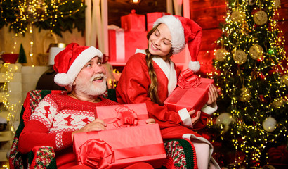 Obraz na płótnie Canvas Granddaughter spend time with grandpa. Christmas eve. Family home. Family relationships. Visiting grandparents. Happy childhood. Family tradition concept. Boxing day. Child christmas with Santa claus