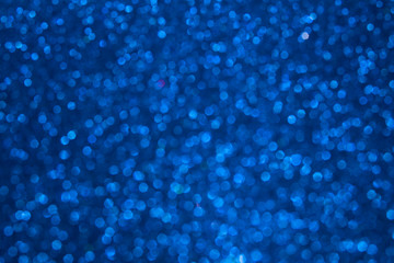 Blue glowing dynamic festive background shining sparkles bokeh. Glitter texture, holidays concept. Trend color 2020, layout for design. Trendy color concept of year, classic blue background.