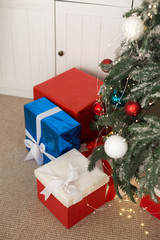 Beautiful Christmas gift boxes on the floor near the Christmas tree.