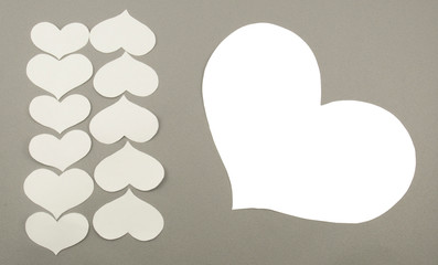 White paper hearts on grey background