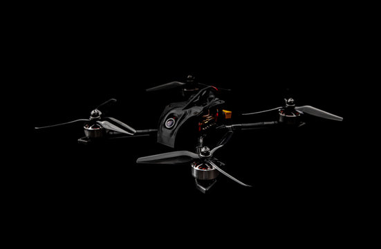 Modern FPV drone on a black background. Four-engine aircraft on the radio control. Drone for racing, filming and entertainment.