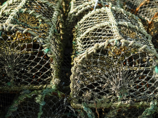 Old used fish and crab traps, Rusty metal frame covered with net. Tool for fish industry.