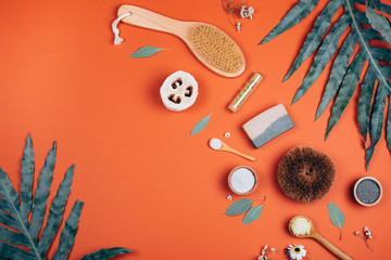 Fototapeta na wymiar Collagen powder or white clay on orange background with palm leaf. Flat lay style.