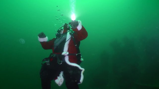 Divers celebrate New Year under water: A diver dressed as Santa Claus looks up towards the water surface.