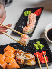 Japanese food sushi roll with raw fish and rice. delivery plastic boxes