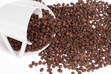 Roasted organic coffee beans - Coffea; photo on white background.