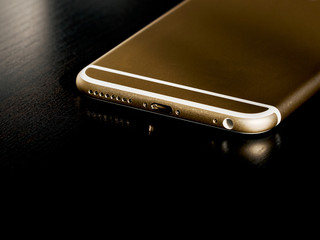 Smartphone bottom on dark table close up