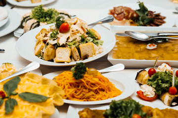 Cold appetizers and salads on the wedding table. Catering service. Restaurant table with food. Huge amount of food on the table. Plates of food. Dinner time, lunch.