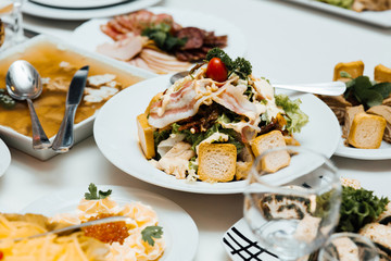 Cold appetizers and salads on the wedding table. Catering service. Restaurant table with food. Huge amount of food on the table. Plates of food. Dinner time, lunch.