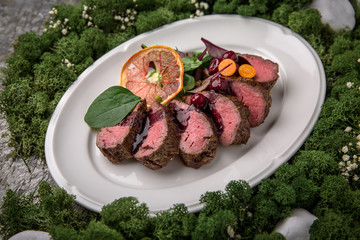 Beef medallions in wild cherry sauce with greens and cherry tomatoes. Banquet festive dishes. Fine dining restaurant menu. Eco life style healthy eating 