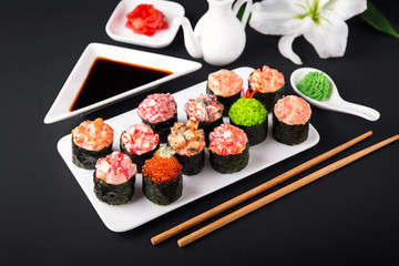 Gunkan sushi set with salmon, tuna, perch, eel, scallop, caviar, shrimp, sharp.  Traditional Japanese cuisine. Black background. Beautiful geometric style food
