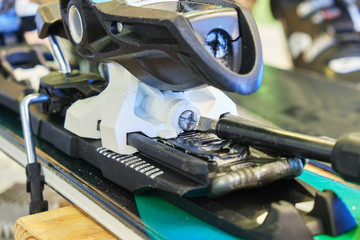 Screw for adjusting forward pressure in a ski binding using a screwdriver, after clipping the ski...