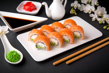 Philadelphia Sushi Roll made of Fresh Salmon, Avocado and Cream Cheese inside. Traditional Japanese cuisine. Asian food