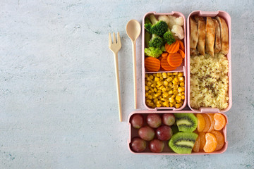 Healthy balanced lunch box on a grey background. Vegetables and fruits food container, top view. Office lunch and healthy lifestyle concept