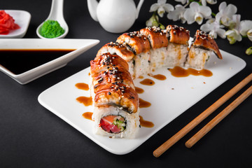 The Luxury Unagi Rol roll with a large slice of smoked salmon in a sauce, with fresh salmon, tuna, Philadelphia cheese, tobiko caviar, cucumber and avocado. Sushi menu. Japanese food. Asian Food