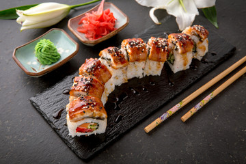 The Luxury Unagi Rol roll with a large slice of smoked salmon in a sauce, with fresh salmon, tuna, Philadelphia cheese, tobiko caviar, cucumber and avocado. Sushi menu. Japanese food. Asian Food