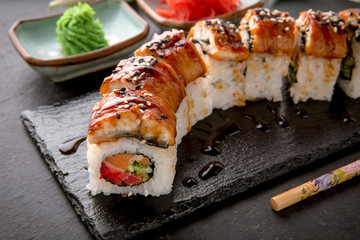 The Luxury Unagi Rol roll with a large slice of smoked salmon in a sauce, with fresh salmon, tuna, Philadelphia cheese, tobiko caviar, cucumber and avocado. Sushi menu. Japanese food. Asian Food