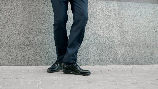 Closeup man feet dancing outside. Cropped image man in shoes dancing at street