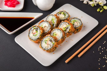 Hot fried Sushi Roll with salmon, tuna, avocado and cheese. Sushi menu. Japanese food.