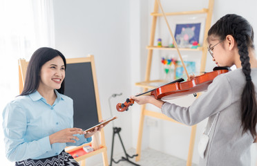 close up hand holding violin, cute asian children playing violin with. teacher, she show violin...