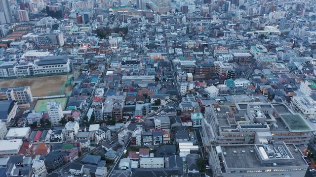 Aerial Kobe, Japan. Tilt up revealing city and harbor at dusk