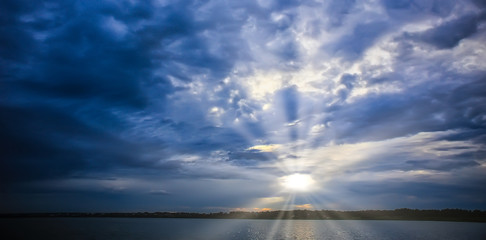 sunset in the cloudy sky above the lake