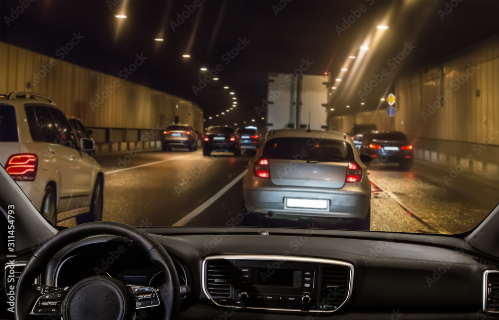 Wall mural view from the car through the windshield of traffic in a tunnel