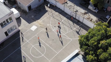Rotating aerial view of teens playing intense soccer football match slow motion - Powered by Adobe