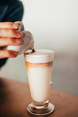 pouring espresso in hot steamed milk 