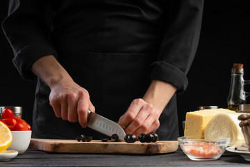 The chef cuts Italian masks to prepare a delicious and fresh salad. Vegetarian and fresh food,...