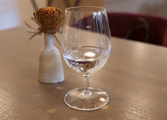 water in a wine glass on a table at a restaurant scene