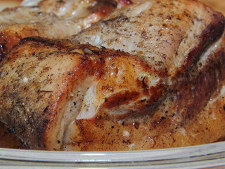 Baked piece of pork meat on aluminum foil, the process of cooking meat dishes in the oven.