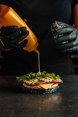 A closeup of a hamburger cooking process. Chef on kitchen table making ingredients for burger