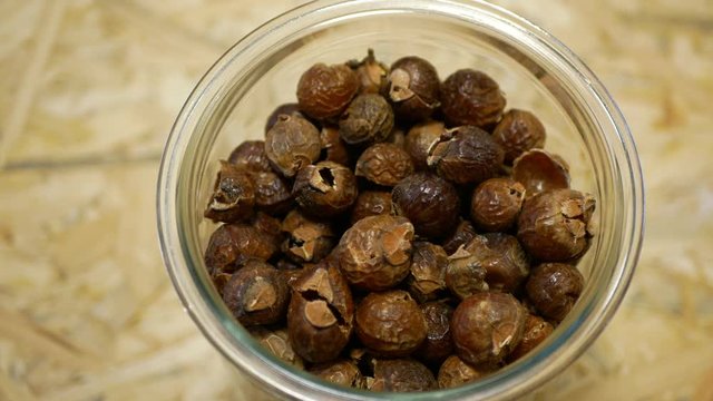 Soap nuts Indian soapberry or washnut glass jar cup, Sapindus mukorossi reetha or ritha from the soap tree shells are used to wash clothes to put drum washing machines. Nuts saponin plant fruit seeds