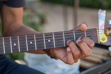 Hipster playing a old wood guitar in happy moment