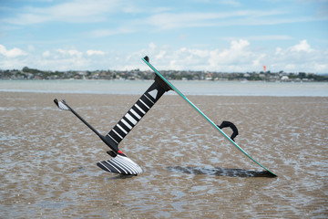 A kitesurfing hydrofoil board on the beach at low tide, Wai O Taki Bay, Glendowie, Auckland, New Zealand.