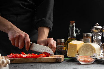 Cook on a wooden board slices cherry tomatoes, close-up, macro. Salad, organic ingredients and...