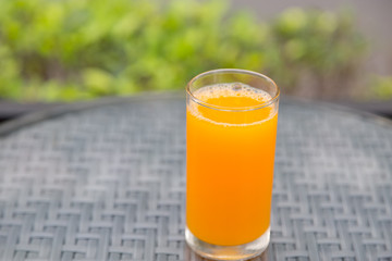 Orange juice glass on the table glass with green