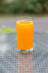 Orange juice glass on the table glass with green