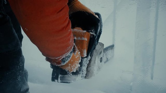 A worker cuts a panel of ice with gasoline, a city decoration for Christmas
