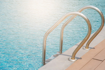 Stairs Ladder and handle down the swimming pool with blue water