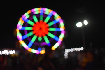 blurred neon light on ferris wheel, festive concept